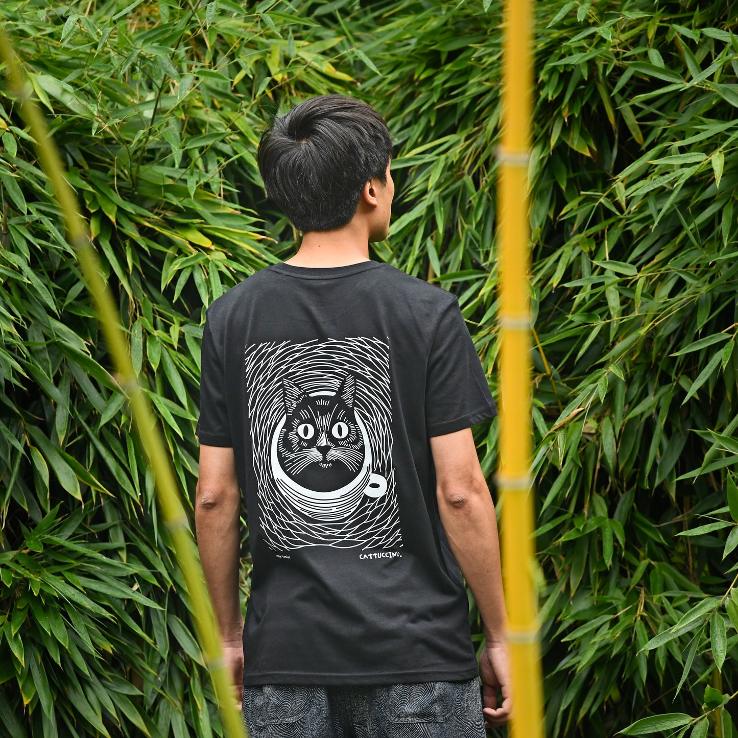 Mannelijk model draagt het zwarte 'Cattuccino' T-shirt. T-shirt in biokatoen met kat en koffie.