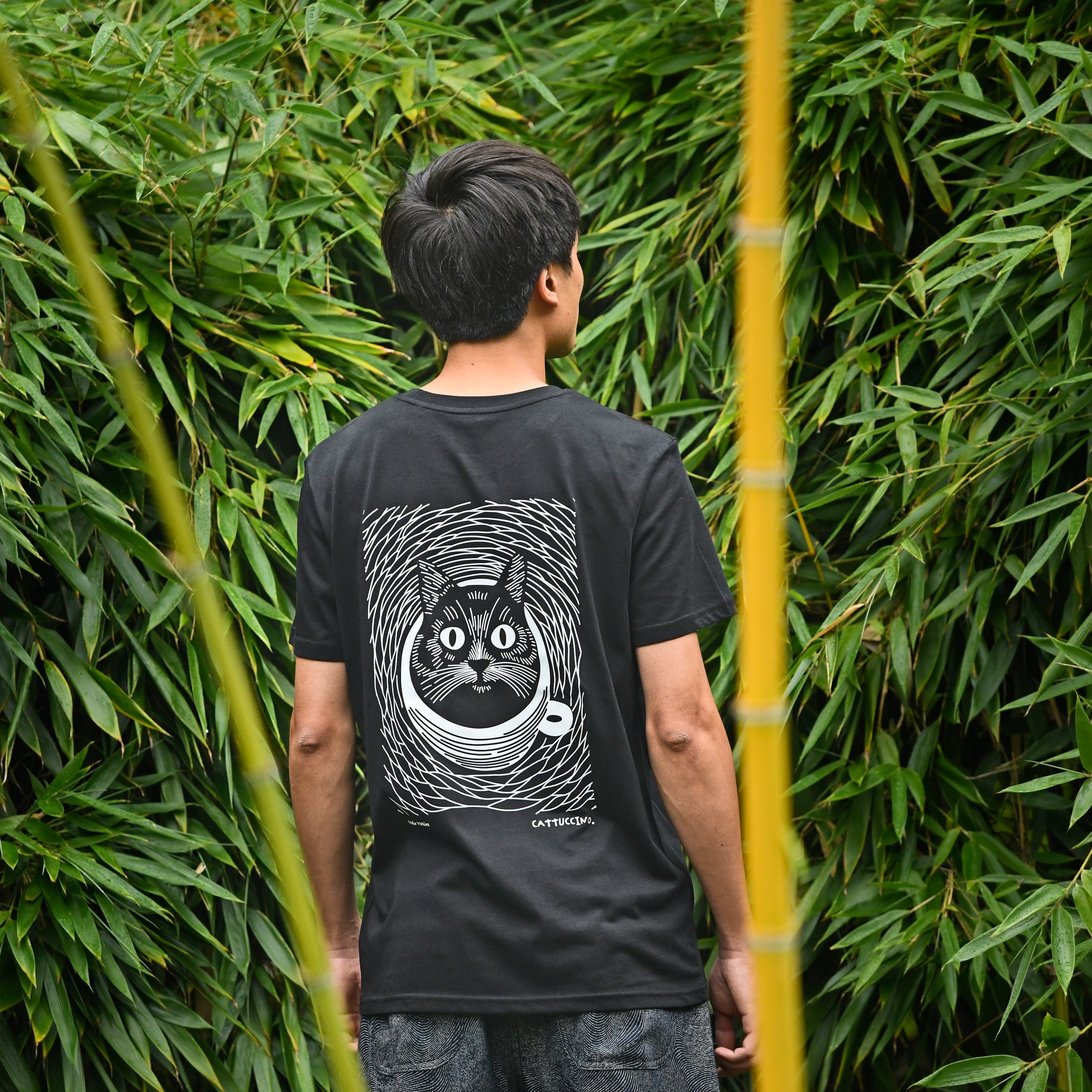 Mannelijk model draagt het zwarte 'Cattuccino' T-shirt. T-shirt in biokatoen met kat en koffie.